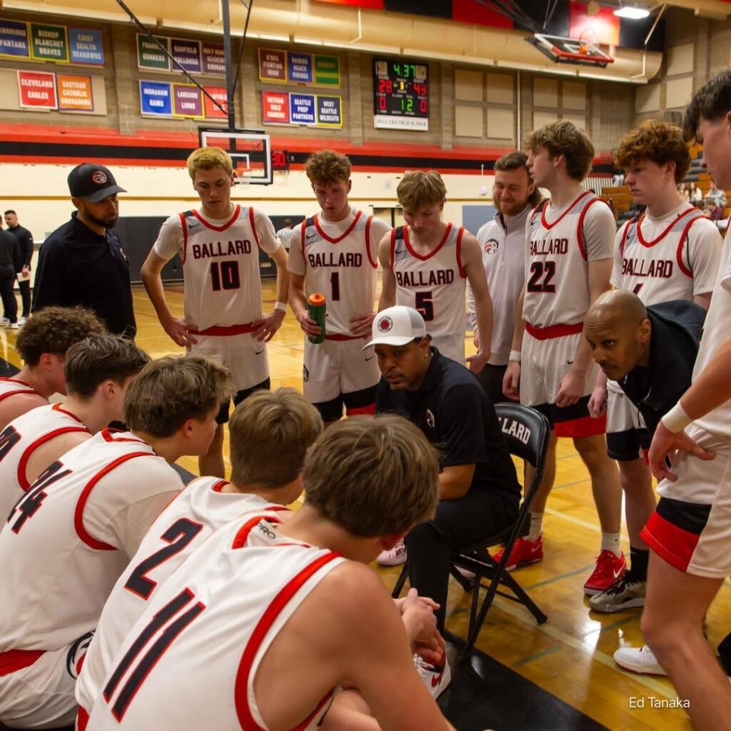 Boys Basketball players on the bench listening to coach Lorenzo Durant III