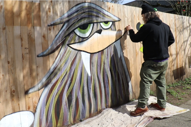 Painter Henry painting on fence.