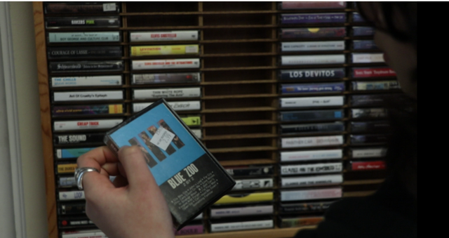 Cassette Cabinet with hand holding a cassette.