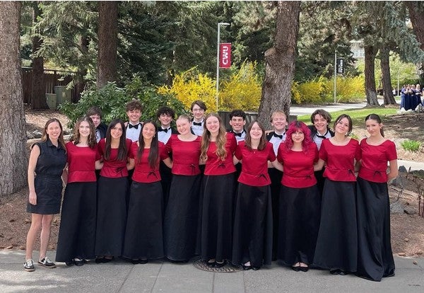 Students in red and black concert attire with Director Courtney