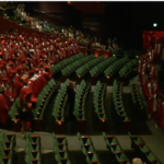 Graduates in robes and cap getting seated at McCaw Hall